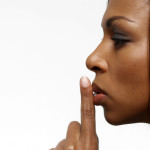 Young Businesswoman with Her Finger on Her Lips